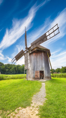 Amazing summer view of traditional romanian windmill. Fantastic rural scene of Transylvania. ...