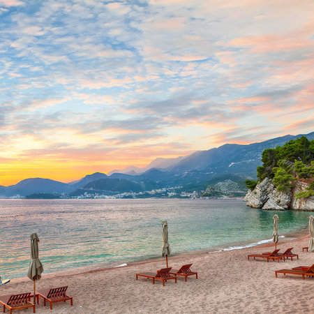 Captivating sunset at beach with chaise lounges and umbrellas in Sveti Stefan near Budva. Location: Budva riviera, Montenegro, Adriatic sea, Europeの写真素材