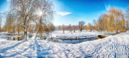 Stunning landscape with snowy trees, beautiful frozen river with reflection in water. Winter landscapeの写真素材