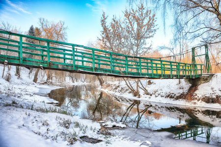 Breathtaking landscape in city park with snowy trees and beautiful reflection in frozen river.  Winter landscapeの写真素材