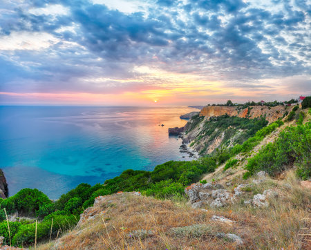 Unbelivable sunset at cape Fiolent with bushes grass and rocks at foreground.  Location: Crimea, cape Fiolentの写真素材