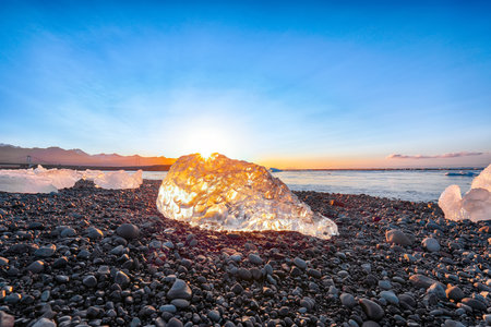 Impressive pieces of the iceberg sparkle on famous Diamond Beach at  Jokulsarlon lagoon during sunset. Location : Jokulsarlon lagoon, Diamond beach, Vatnajokull national park, Iceland, Europeの写真素材