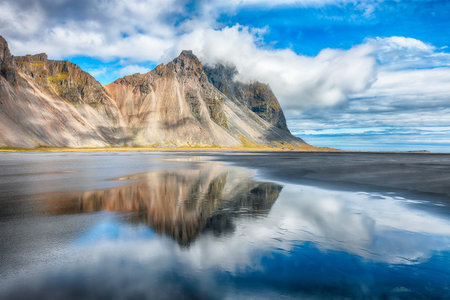 Impressive  sunny day and gorgeous reflection of Vestrahorn mountaine on Stokksnes cape in Iceland. Location: Stokksnes cape, Vestrahorn (Batman Mount), Iceland, Europe.の写真素材