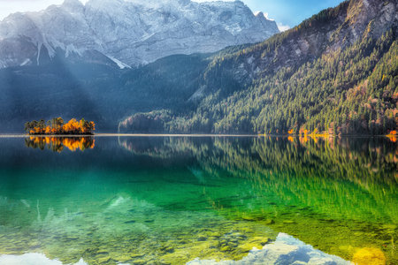 Amazing autumn landscape of Eibsee Lake in front of Zugspitze summit under sunlight. Location: Eibsee lake, Garmisch-Partenkirchen, Bavaria state, Germany, Europeの写真素材