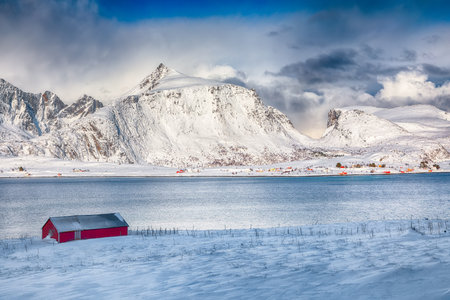 Amazing  winter view on Selfjorden with small fishing houses (rorbu) and snowy peaks on background. Location: Flakstadoya island Lofoten; Norway, Europeの写真素材