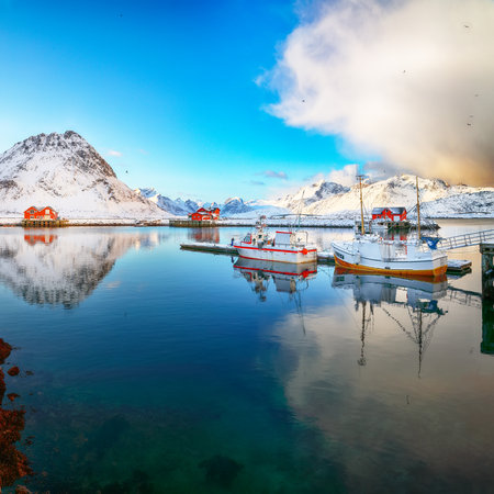 Unbelivable winter sunrise over Ramberg village and harbour. Moored fishing ships in port. Location: Ramberg, Flakstadoya island, Lofoten; Norway, Europeの写真素材