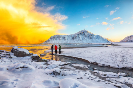 Group of tourist looking  on Skagsanden beach with illuminated clouds during sunrise. Popular tourist destination. Location: Flakstadoya island, Lofoten; Norway, Europeの写真素材