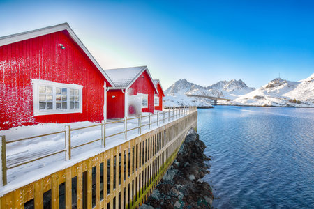 Amazing scenery with traditional Norwegian red wooden houses on the shore of  Sundstraumen strait....