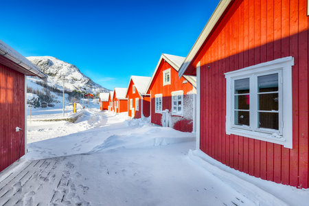 Amazing scenery with traditional Norwegian red wooden houses on the shore of  Sundstraumen strait. Location: Flakstadoya island, Lofoten; Norway, Europeの写真素材