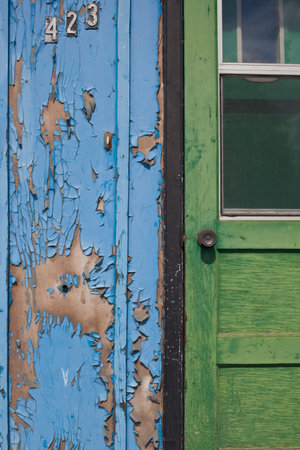 Peeling paint on exterior door and wall of abandoned building, in desperate need of a paint jobの写真素材