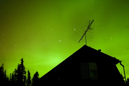 Bright northern lights (Aurora borealis) above house in northern Canada.の写真素材