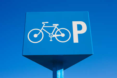 Blue parking bicycle sign on blue sky background.の写真素材