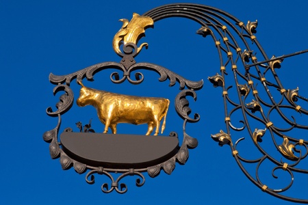 Beautifully crafted wrought iron sign with golden ox with empty copyspace for your message.の写真素材