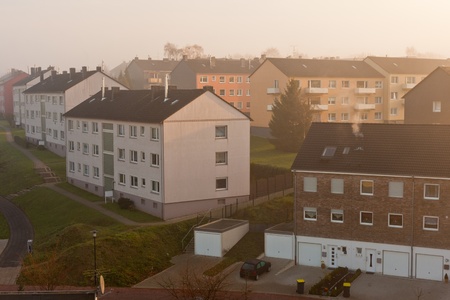 Morning fog in typical German small city suburb of apartment buildings (Germany, Europe).の写真素材