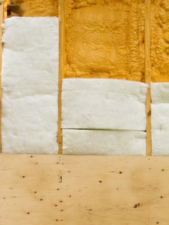 Different types of building insulation: polyurethane spray foam and fiberglas mats.の写真素材