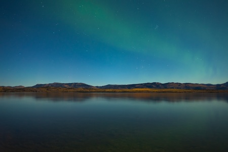 Northern lights (Aurora borealis) in moonlit night over Lake Laberge, Yukon, Canada, in fall.の写真素材