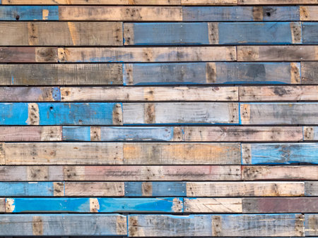 Background texture pattern of weathered wooden planks with grungy remnants of blue paint forming the...