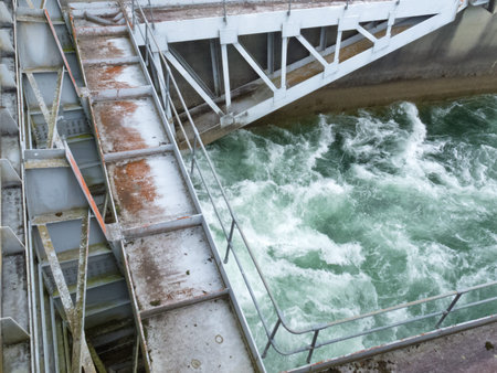 Hydro control structure weir with flow passing underneath causing a violent turbulence discharge of...