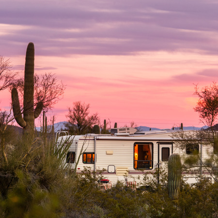Fifth Wheeler RV parked on campsite in Sonoran Desert beside Saguaro Cactiの写真素材