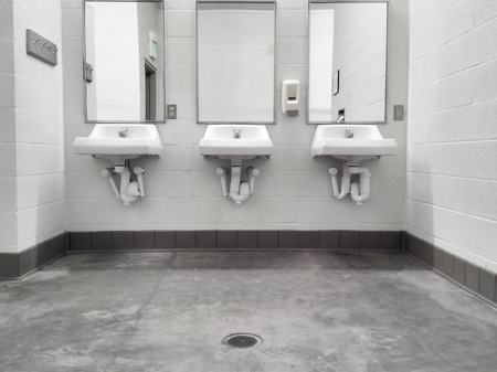 Simple but clean public washroom, row of sinks and mirrors, grungy faded-color mobile shotの写真素材