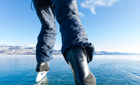 Skating on ice of frozen Lake Laberge wild winter landscape, Yukon Territory, Canadaの写真素材