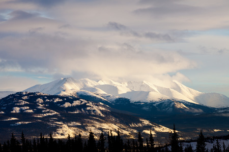 Winter mountain range towering over scenic wilderness landscape of Yukon Territory, Canadaの写真素材