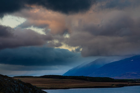 Storm clouds at sunset over Eyjafjordur fiord forming dramatic skyscape near Akureyri, Iceland, IS,...