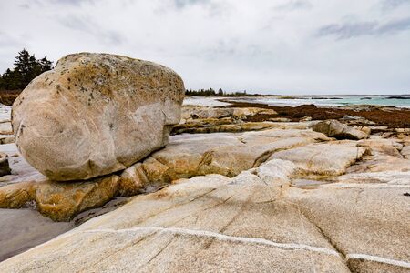 Granite boulder on rocky shore coast of Atlantic Ocean coastal landscape of rural Nova Scotia, NS, Canadaの写真素材