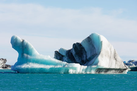 Blue dirty glacier iceberg frozen ice calved from Vatnajokull icefield Vatnajokull National Park,...
