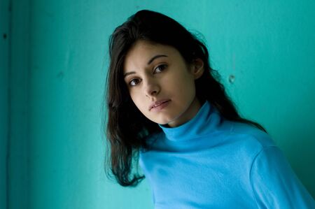 Portrait of the beautiful girl with turquoise backgroundの写真素材