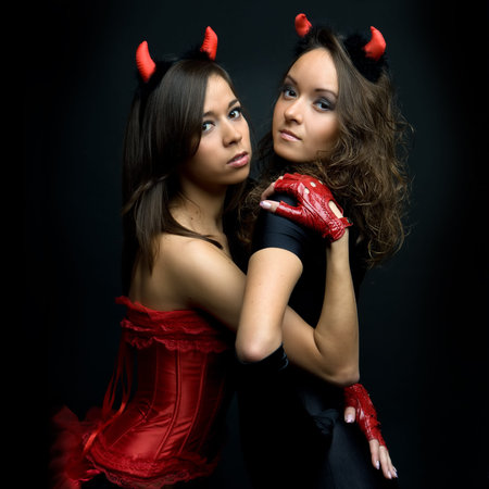 Two beautiful women in devil costumes. 