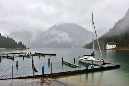 Plansee lake in Austria. Raining froggy autumn day.の写真素材