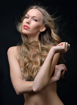 Portrait of the beautiful blonde woman in a striped swimwear. Studio shooting.の写真素材