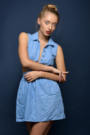 Beautiful sexy blonde woman in jeans dress. Studio shooting.の写真素材