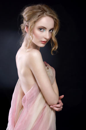 Torso portrait of the  beautiful woman draped in transparent dress. Dark backgroundの写真素材