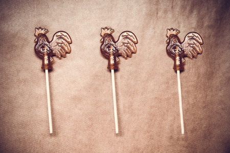 sugar lollipop roosters on wooden paper editedの写真素材