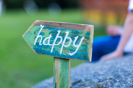 word happy on pointer to the path  with a young man in the backgroundの写真素材