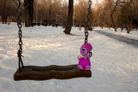 funny doll swinging on a swingの写真素材