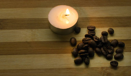 coffee beans and a lighted candleの写真素材