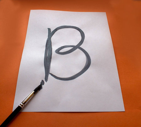 letter b written by a brush on a white sheetの写真素材