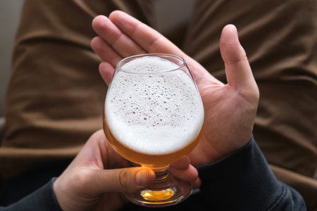 A glass of beer in the hands of a man. Tasting brewed craft beer. Lager beer with beautiful foam....