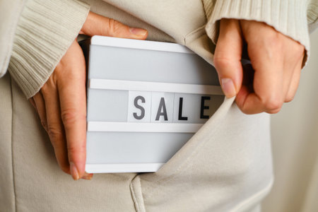 Light box with text SALE in the hands of a girl. Season sale, holiday shopping. Special offer for consumers. Advertisement promotion with discount. Marketing promotionの写真素材