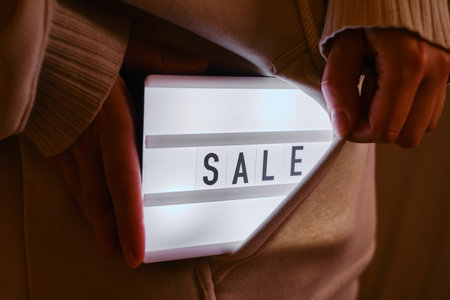 Light box with text SALE in the hands of a girl. Season sale, holiday shopping. Special offer for consumers. Advertisement promotion with discount. Marketing promotionの写真素材