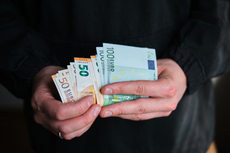 Man holds money in his hands. Cash in Euro for payment or exchange. Male counts salary in euro banknotes. Saving money, withdrawal banking deposit. European money. Financial crisisの写真素材
