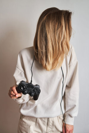 Gamepad in the hands of a girl. Gamer with joystick. Player play in computer and console games....