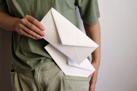 Woman holds in hand paper envelope. New mail, message. Postal service. Young girl want send or...