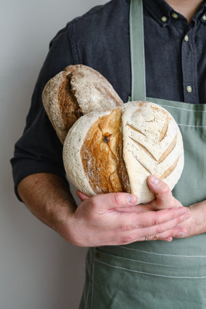 Crispy fresh bread in the hands of a man. Rustic organic wheat bread. Gluten free. Home baking bread...