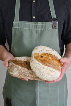 Crispy fresh bread in the hands of a man. Rustic organic wheat bread. Gluten free. Home baking bread...