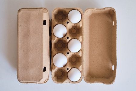 Cardboard boxes with chicken eggs. Boxes with uncooked eggs in table. Natural organic farm product. Preparing for Easter holiday. Fresh food delivery, carton packageの写真素材