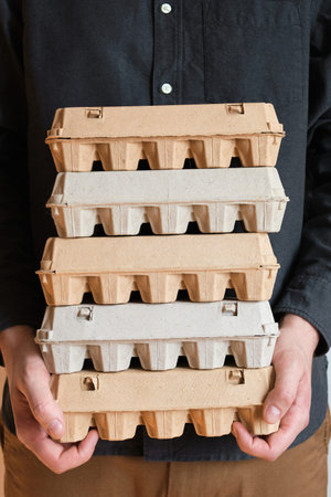 Cardboard boxes with chicken eggs. A man holds boxes with uncooked eggs. Natural organic farm...